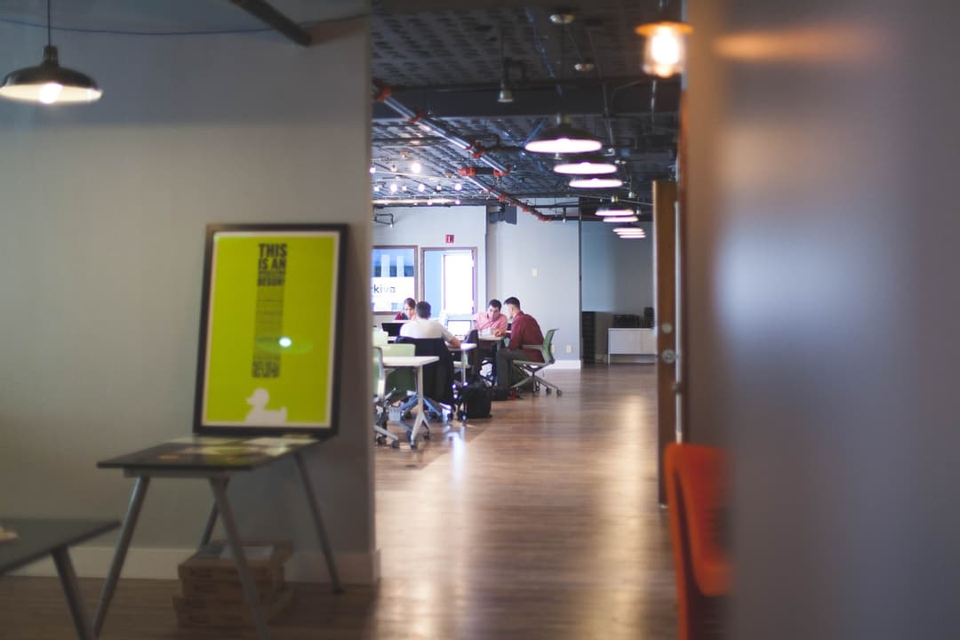 Modern office space with glass partitions and green accents